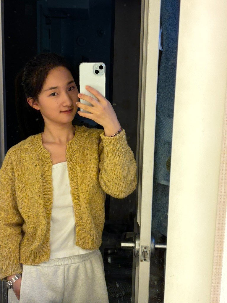 Jie Grace Li wearing a hand-knitted yellow cardigan