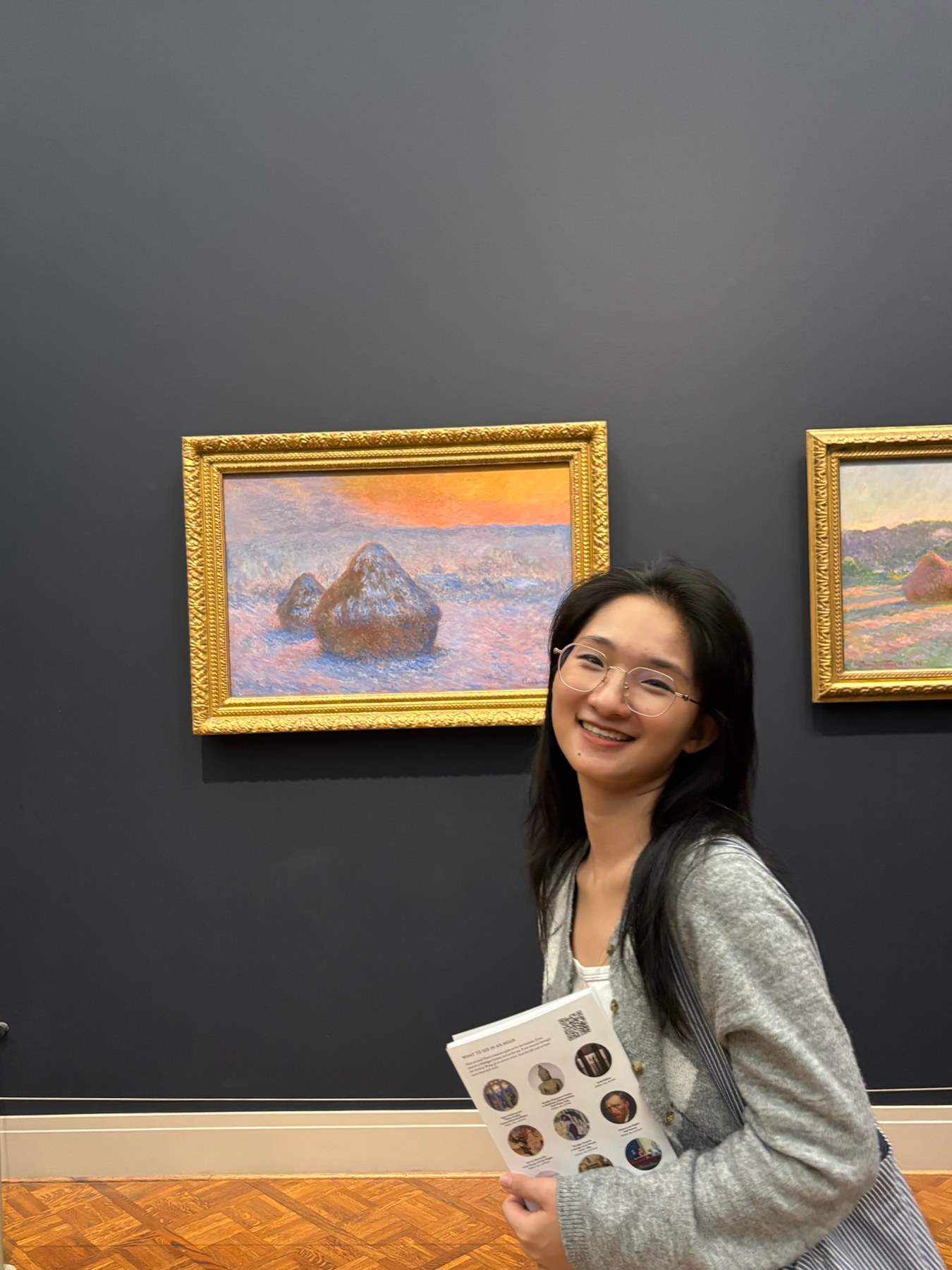 Jie Grace Li beside a landscape painting in an art museum